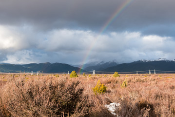 Rainbow against snow capped mountain