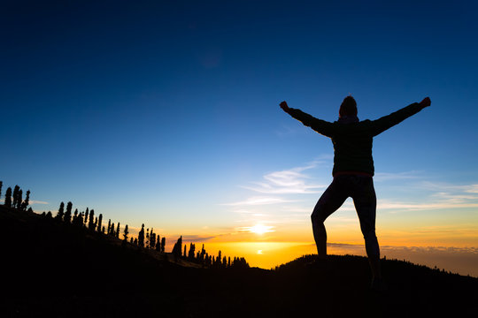 Woman hiker with arms outstretched enjoy mountains