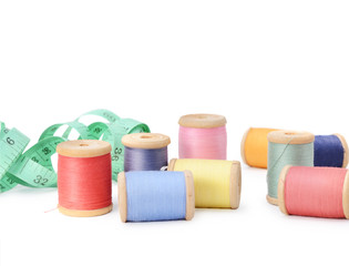 Plenty multicolor threads bobbins isolated on white background. Atelier, sewing accessories backdrop.