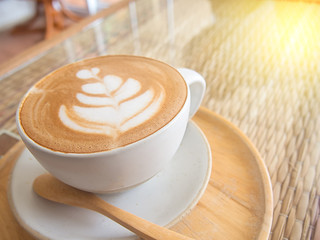 beautiful foam in coffee cup on table with sun light