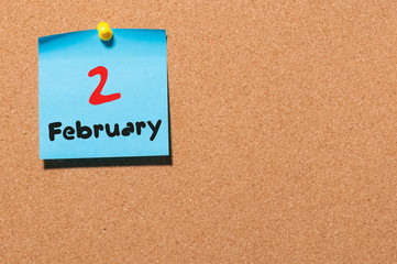 February 2nd. Day 2 of month, calendar on cork notice board background. Winter time. Empty space for text