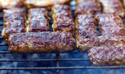 Minced meat rolls on grills