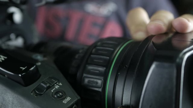Camera operator working with a cinema broadcast camera at the unrecognizable tv news studio. 4K.