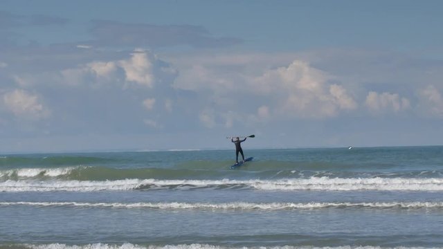 surfeur avec les falaises anglaises &agrave; l'horizon(4k)