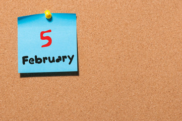 February 5th. Day 5 of month, calendar on cork notice board background. Winter time. Empty space for text