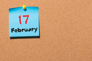 February 17th. Day 17 of month, calendar on cork notice board background. Winter time. Empty space for text