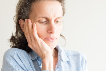 Close up of middle aged woman with hand on face