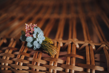 Wedding. groom boutonniere lying on a wicker chair