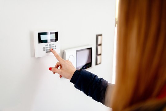 Young woman entering security code on keypad
