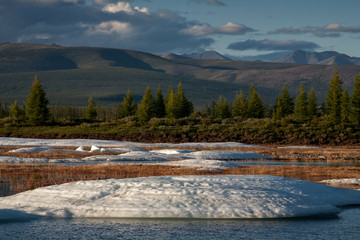 Melting ice field in the valley. Big Moma frost. Moma Mountains. Yakutia. Russia.