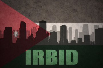 abstract silhouette of the city with text Irbid at the vintage jordan flag background