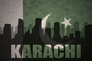 abstract silhouette of the city with text Karachi at the vintage pakistan flag background