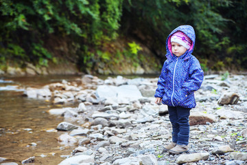 little girl stands near the river.  The concept of travel