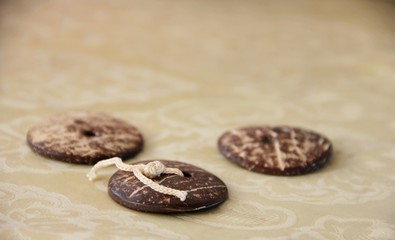 three vintage brown buttons on the table