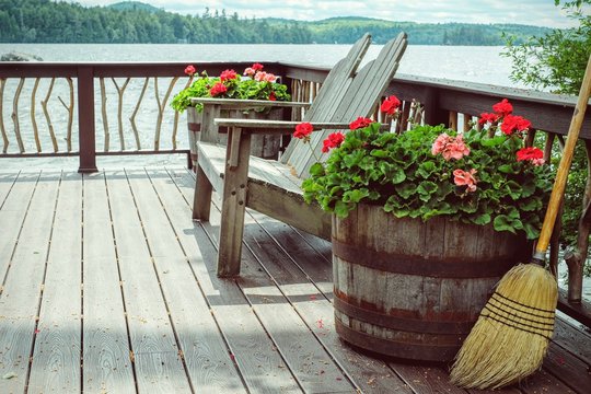Wooden Deck At Lake Cabin With Adirondack Chairs