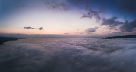 Aerial view over the sea, flying above the clouds.