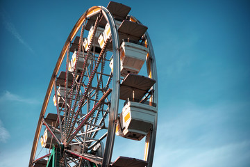 aged and worn vintage photo of ferris wheel with palm trees