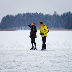 Fototapeta na wymiar Young girl and fellow ice skating in Trakai