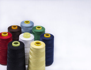 Colorful assortment of vivid colors of cotton spools on cones for use in the knitwear and garment industry viewed high angle