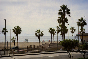 Fototapeta na wymiar aged and worn vintage photo of Huntington Beach California with palm trees
