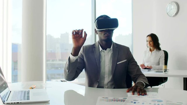 Young black man wearing virtual reality headsets in white future white office