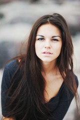 Obraz premium Portrait of beautiful dark-haired young woman on blurred backgro