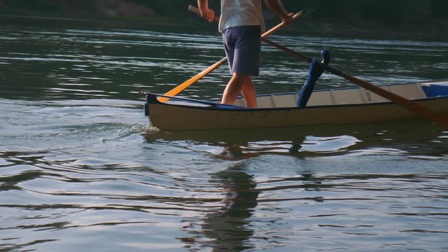 Man rowing in Valesana style with two oars on Ticino River, Italy
