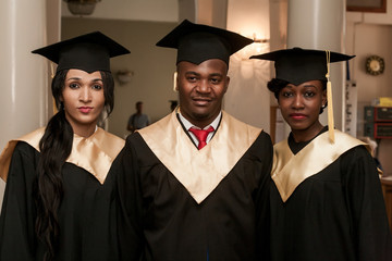 Portrait of happy students in graduation gowns