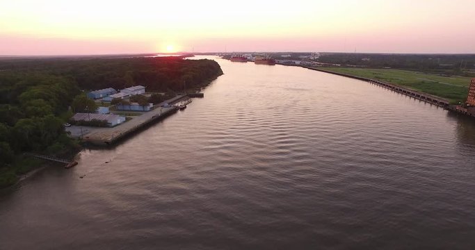 Aerial of the Savannah River at sunrise with an industrial port downriver.