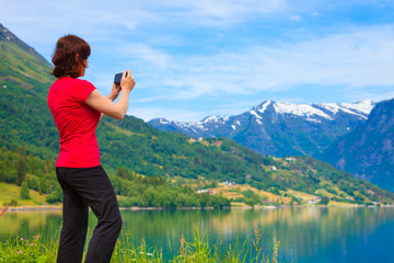 Tourist taking photo at norwegian fjord