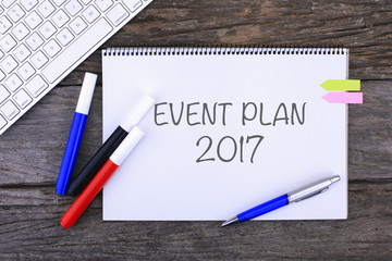 Notebook with EVENT PLAN 2017 Handwritten on wooden background