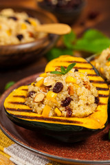 Pumpkin Acorn Stuffed with Quinoa, Nuts and Dried Fruit. Selective focus.