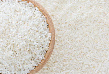 grains of Thai jasmine rice in wooden bowl on white rice background, top view with copy space, high resolution product.