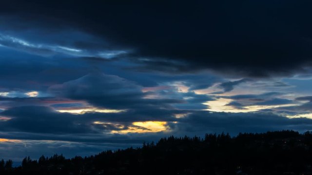 Time lapse movie of moving clouds over residential homes and landscape of Happy Valley Oregon from sunset into blue hour into night 4k uhd