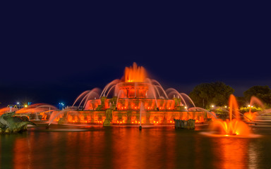 Obraz premium Chicago skyline panorama with skyscrapers and Buckingham fountain in Grant Park at night lit by colorful lights.