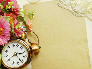 spring time with alarm clock and artificial flowers bouquet background