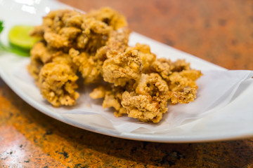 Fried squid on white plate .