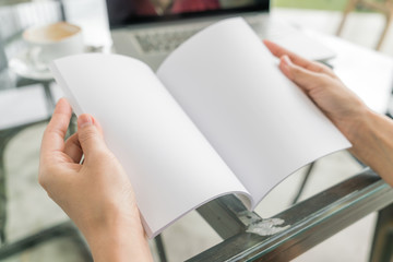Hands open book on table .