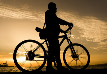 Obraz premium Silhouettes of biking man at beautiful sunset