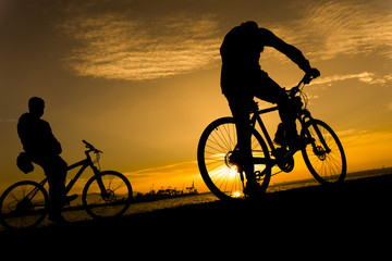 Fototapeta na wymiar Silhouettes of biking man at beautiful sunset