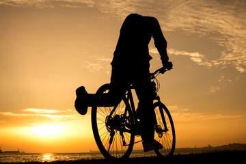 Obraz premium Silhouettes of biking man at beautiful sunset