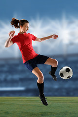 Female Soccer Player Kicking Ball