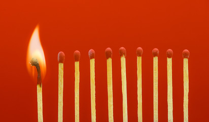 Burning matchsticks setting fire to its neighbors