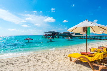 Fototapeta na wymiar Sunbed and umbrella at Maldives island with white sandy beach an