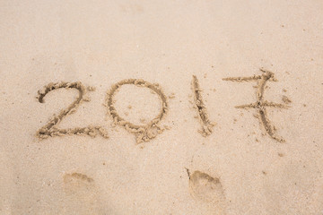 New Year 2017 is coming concept - inscription 2017 on a beach sand