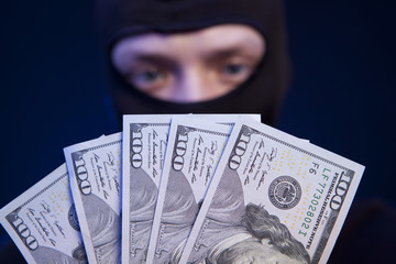 Robber holding money isolated on dark blue