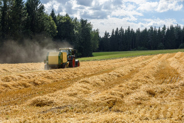 Obraz premium Tractor on field - harvesting the corn