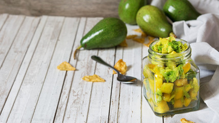 
Homemade mango salsa with avocado on the rustic table. Mexican food. Vegetarian food concept.