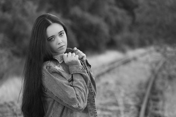 Portrait of young woman standing on railroad track