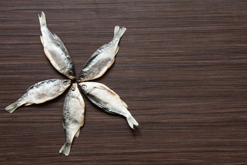 Dried roach on the dark brown background - good snack to beer